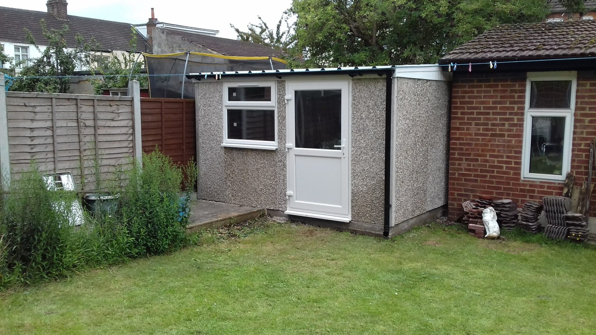 lean to front building pebbledash upvc half glazed door upvc window gutter to front 02 scaled